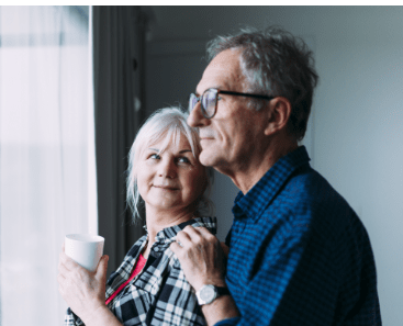 couple standing next to each other looking out window